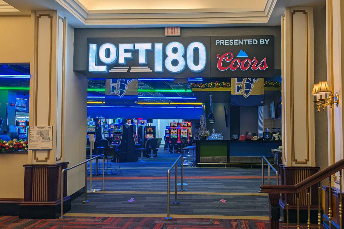 Entry walkway with machines in the background and signage with Loft 180 presented by Coors logo's